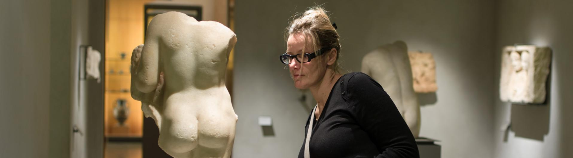 femme admirant statue gréco romaine