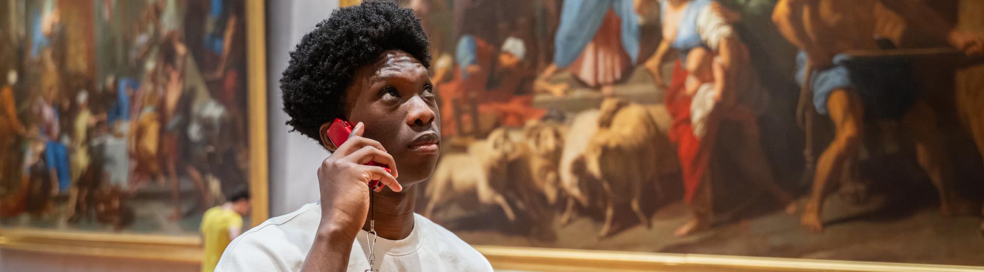 Kevin (homme) qui utilise un audioguide.