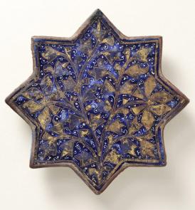 Plaque de revêtement en forme d'étoile à quatre branches, Céramique siliceuse à décor de "lajvardina" (petit feu) doré sur glaçure bleue, Iran, fin du XIIIe siècle, Lyon, musée des Beaux-Arts