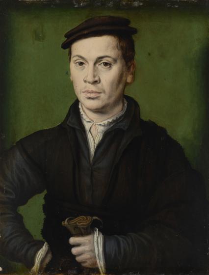 Homme au béret noir portant une paire de gants.