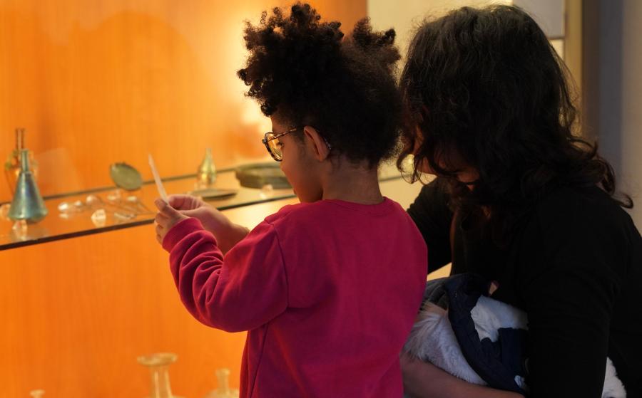 Des visiteurs devant une vitrine